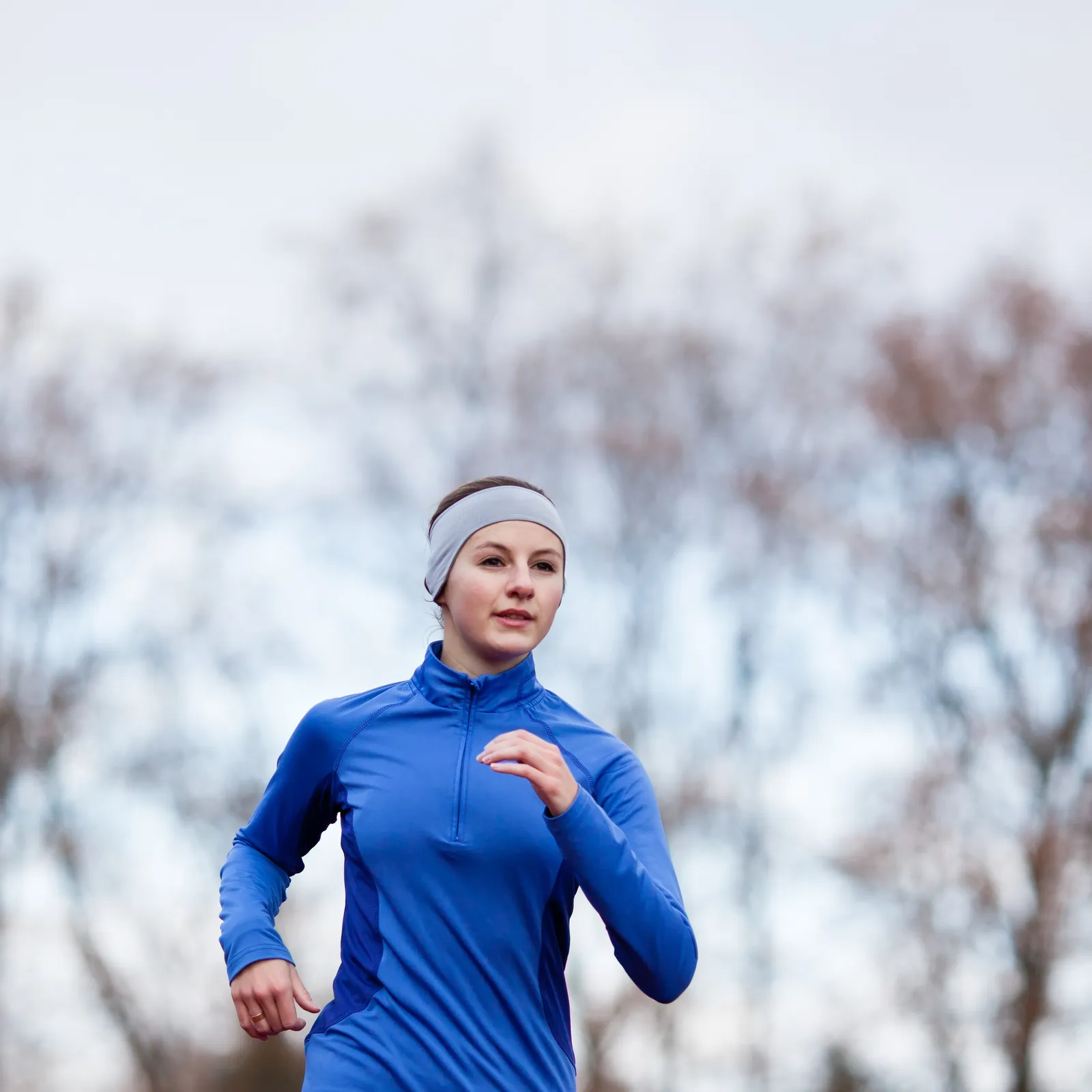 Portrait of a woman running against against blue sky