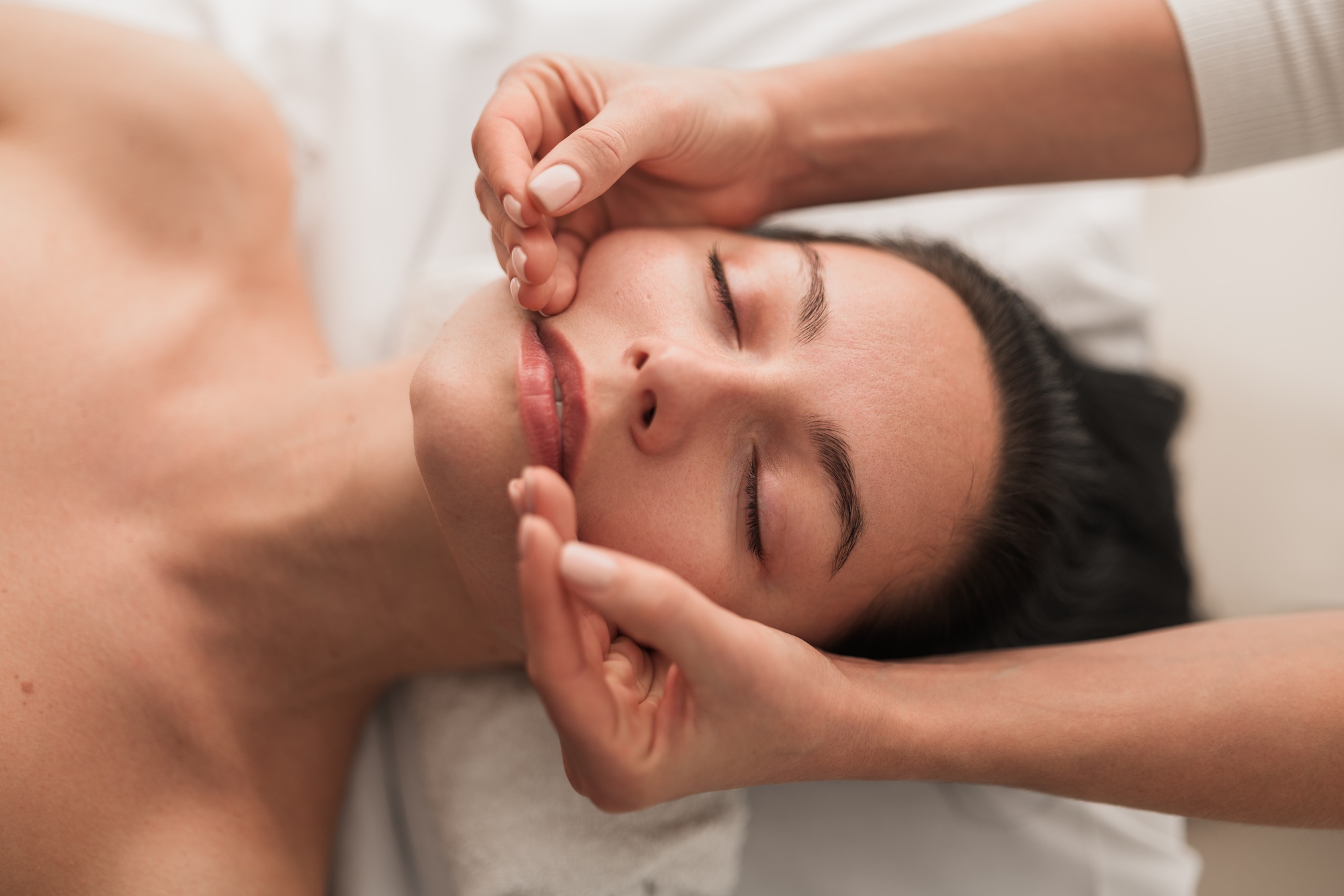 Woman getting facial massage in salon